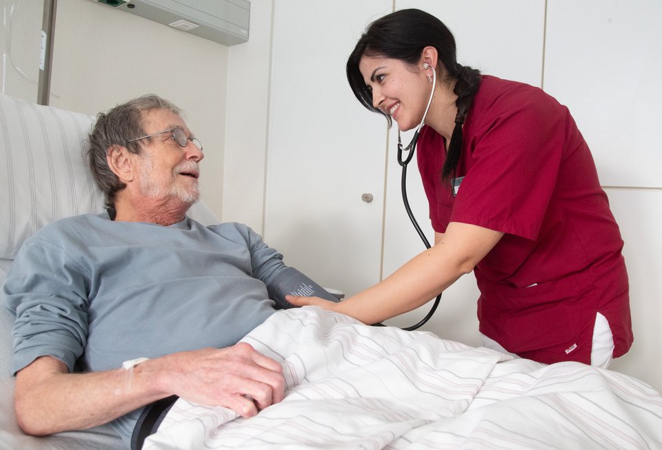 Pflegekraft misst Blutdruck eines Patienten